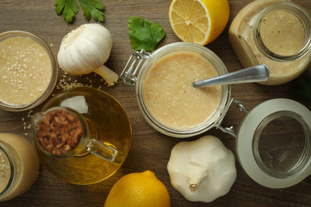 Preparación profesional de cocina vegetal que ilustra la potenciación del sabor en platos veganos con fermentos y especias.