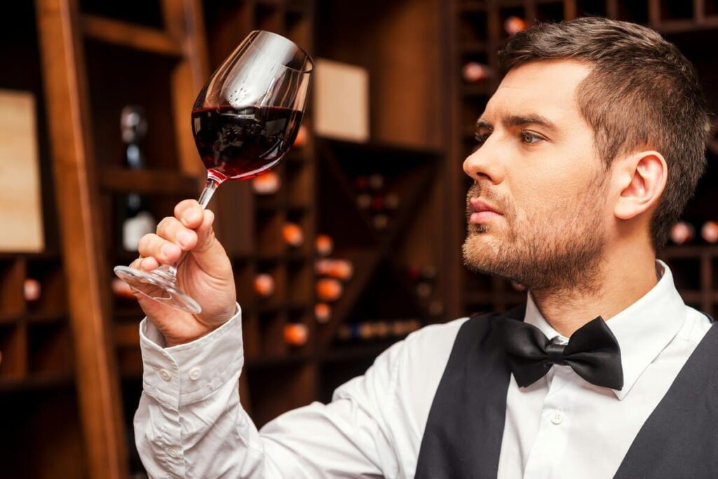 Sommelier realizando un análisis sensorial aplicado al maridaje de vinos y platos gourmet.
