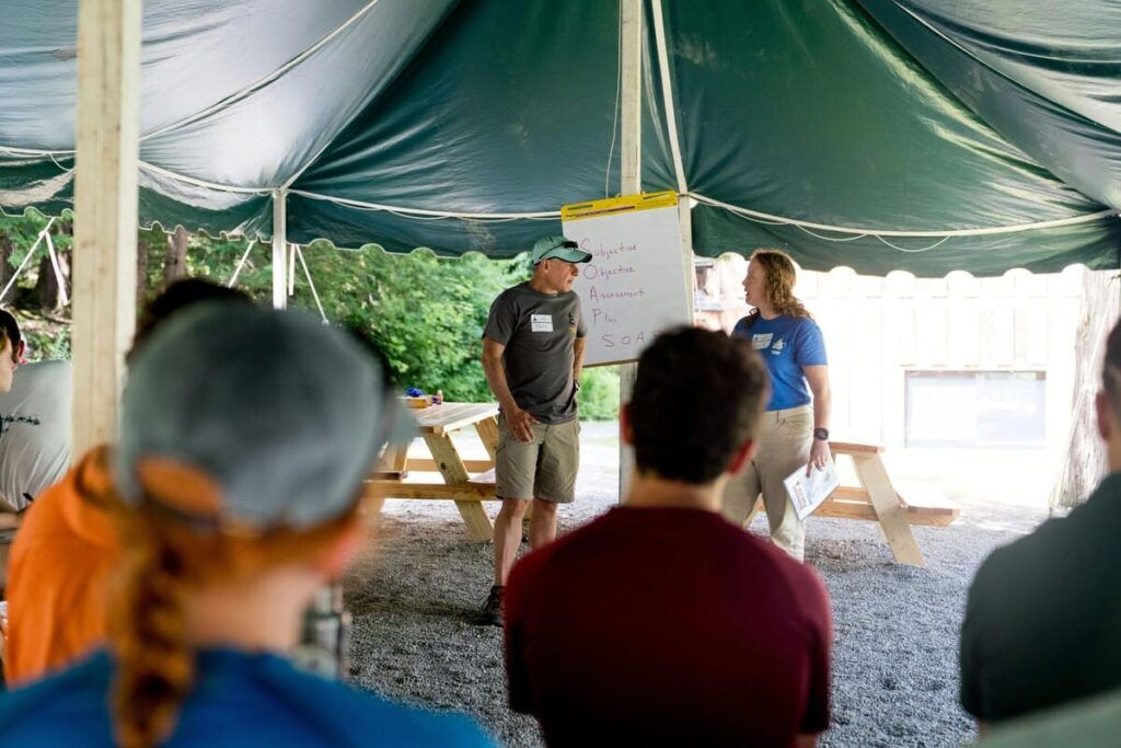 Monitor coordinando un juego deportivo al aire libre, ejemplificando cómo trabajar como monitor de tiempo libre.