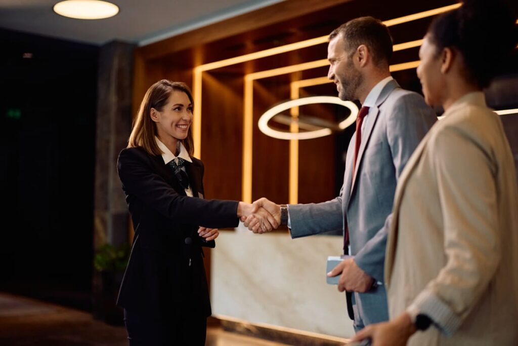 Recepcionista atendiendo a un huésped para ilustrar la importancia de especializarse en Customer Experience hotelero.