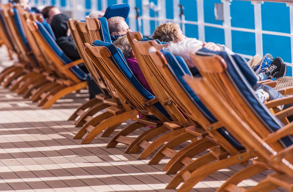 Pasajeros descansando en tumbonas en la cubierta de un crucero.